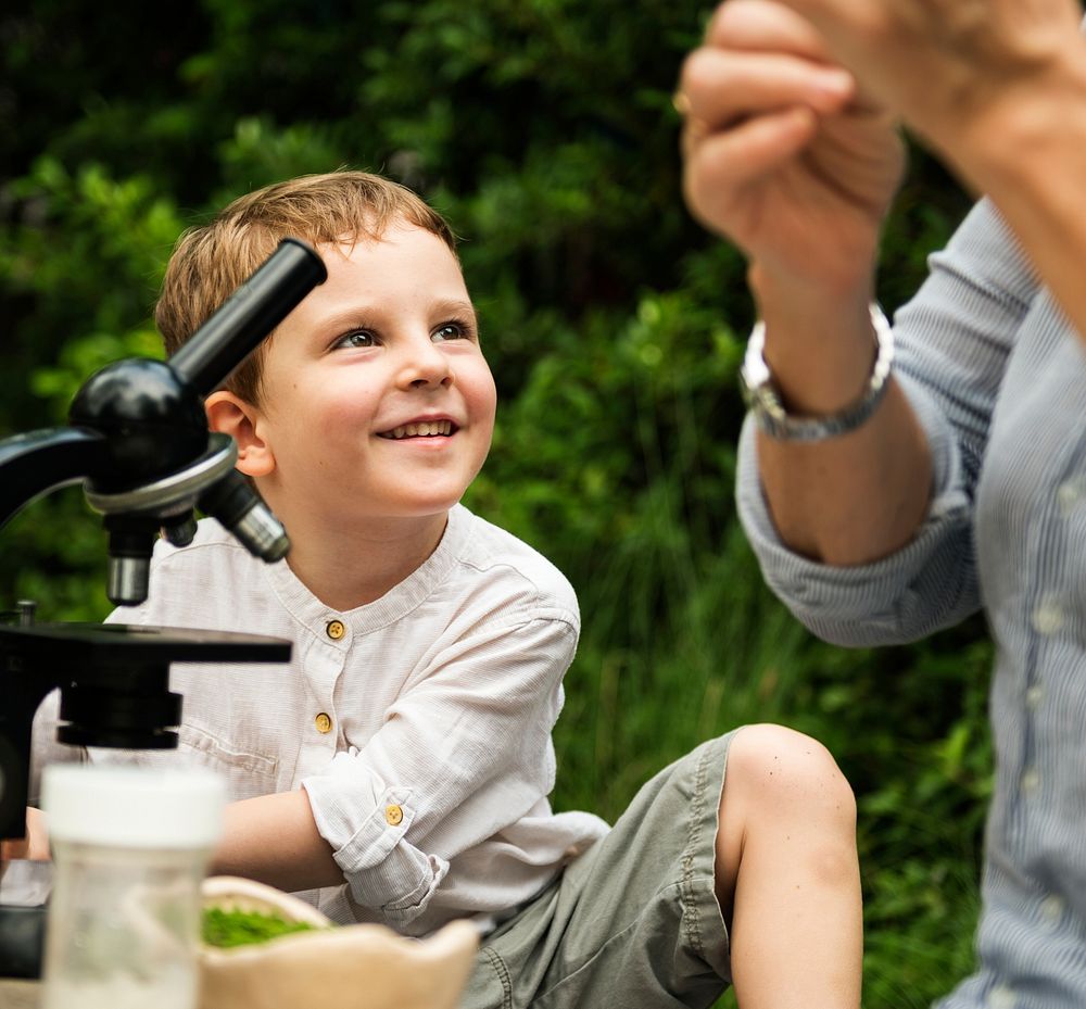 Young boy learning with outdoors with a telescope