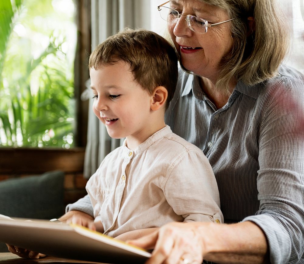 Grandmother and grandson reading a book together