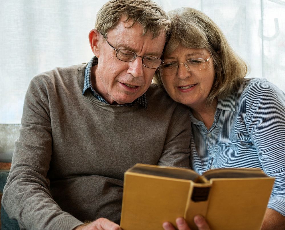 Old caucasian couple reading a book together