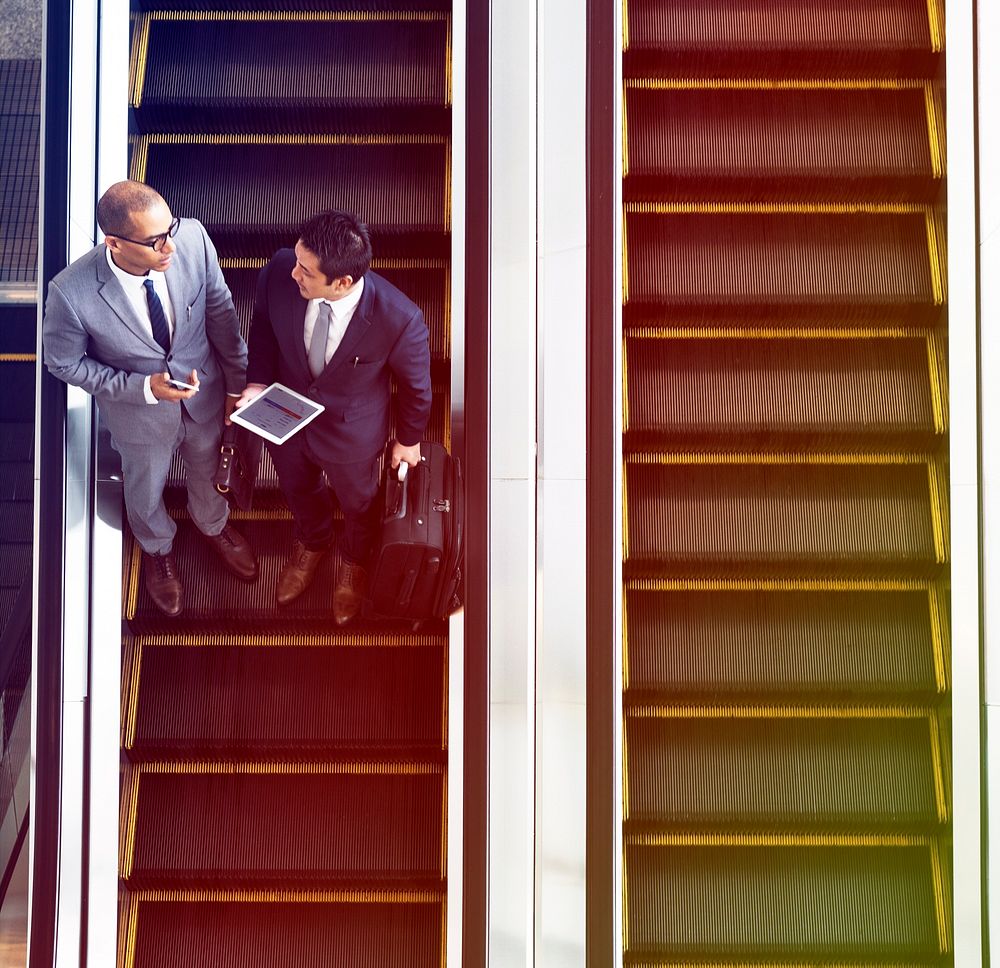 Businessmen discussion using escalator