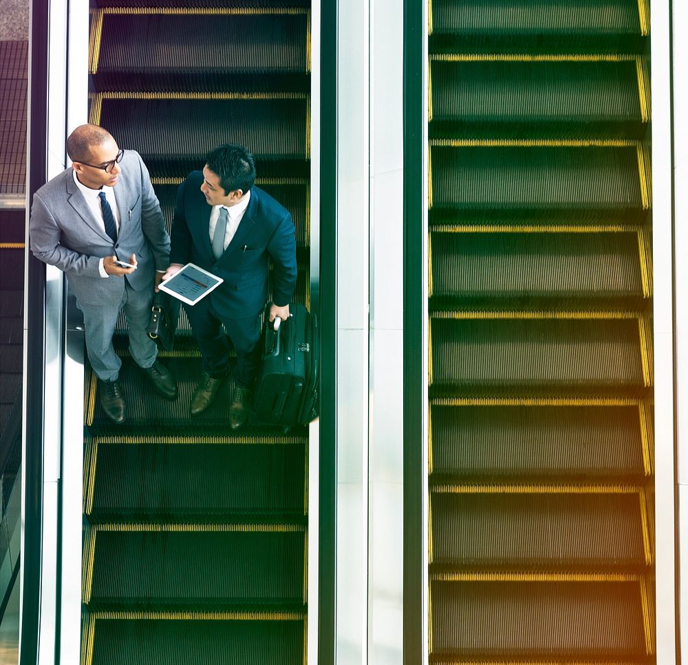 Businessmen discussion using escalator