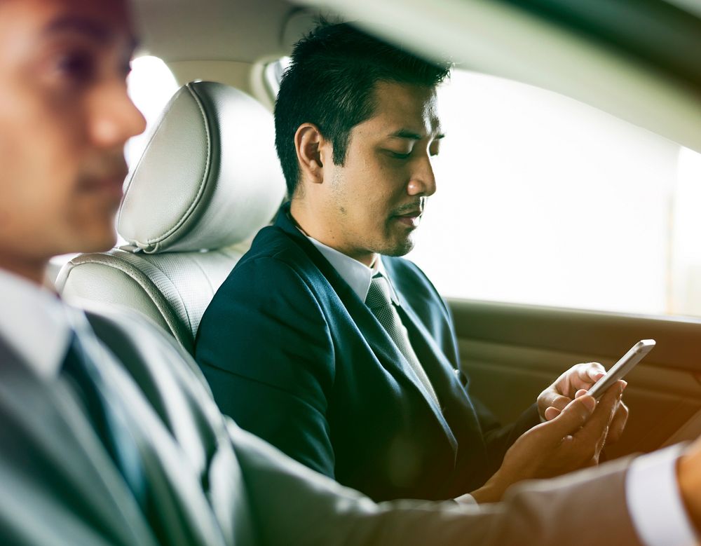 Businessmen using digital tablet into the car