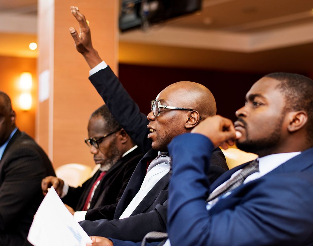 An African Descent Business Man Raising Hand in a Meeting