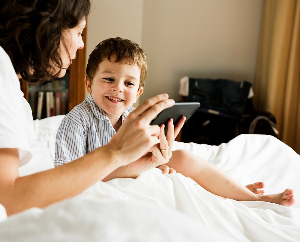Mother sharing something on her phone to a son.
