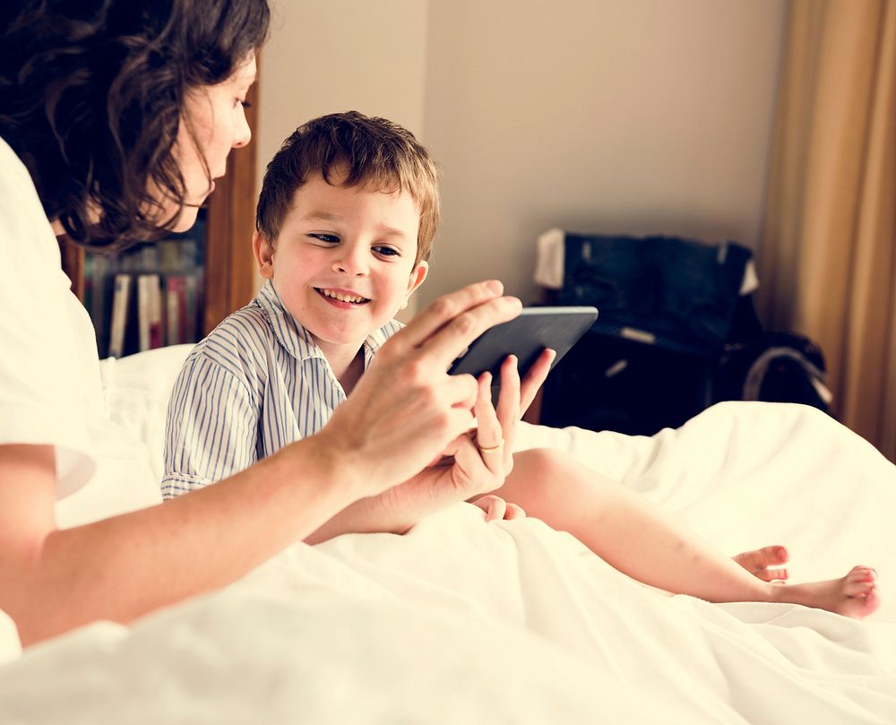 Mother sharing something on her phone to a son.
