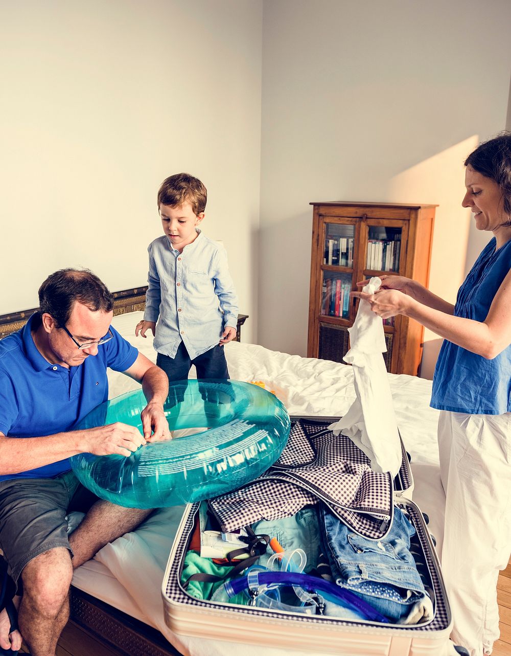 Son is helping their parent to pack a clothes.