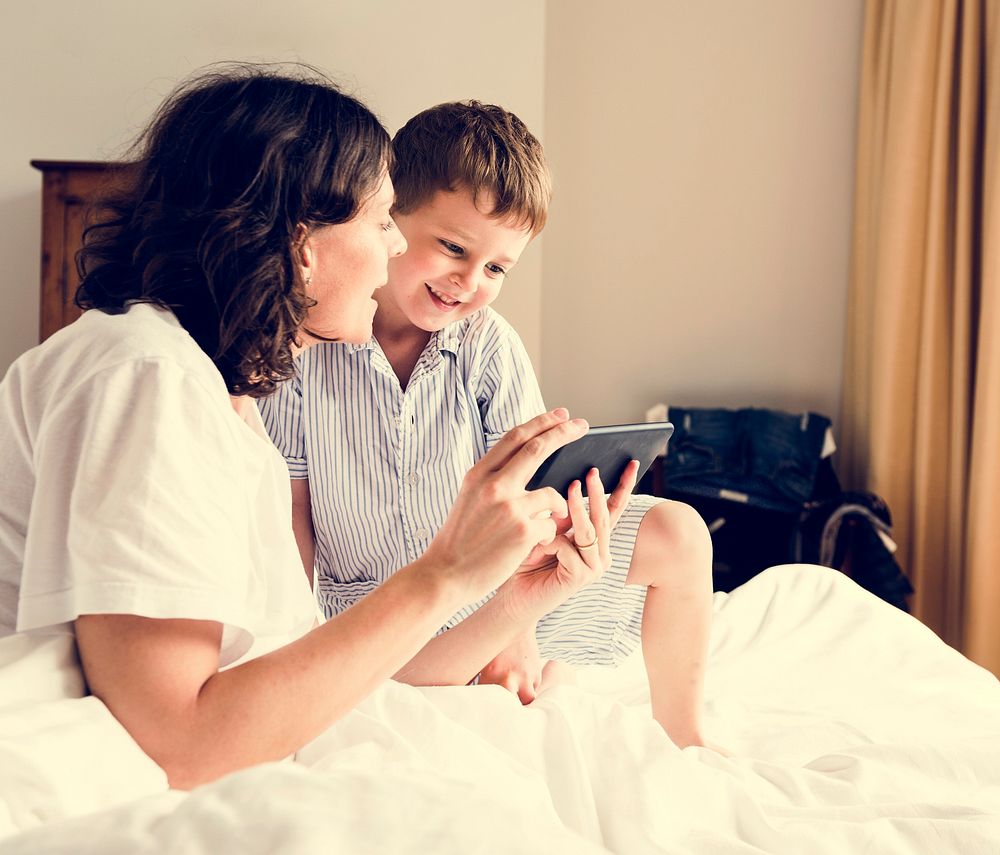 Son and Mom Using Smart Phone in Pyjamas