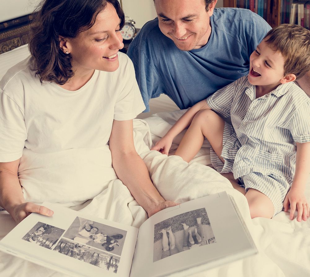 Family Looking Photobook Together at the Bedroom