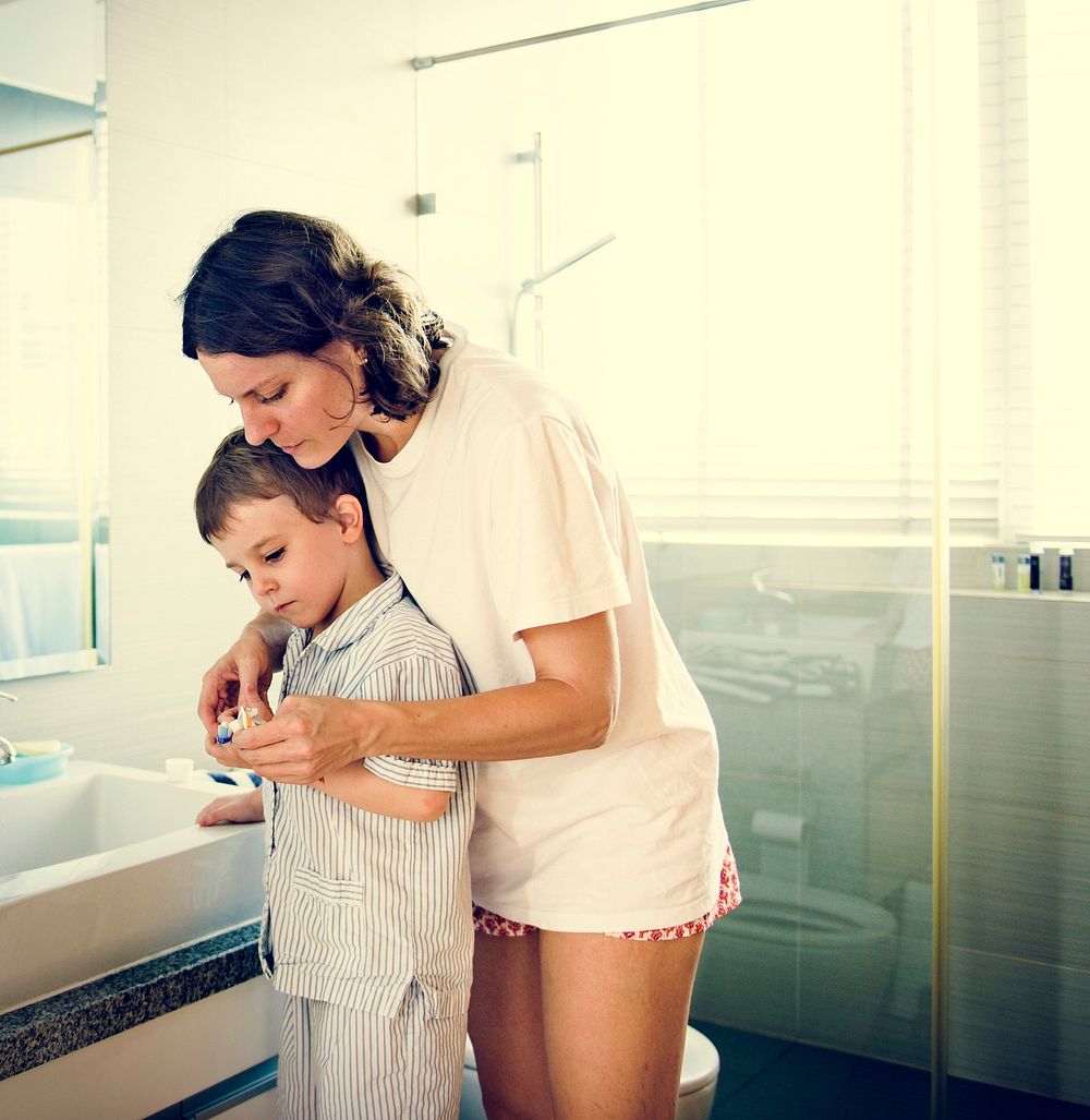 Mom Teaching Son Use Toothbrush in the Toilet