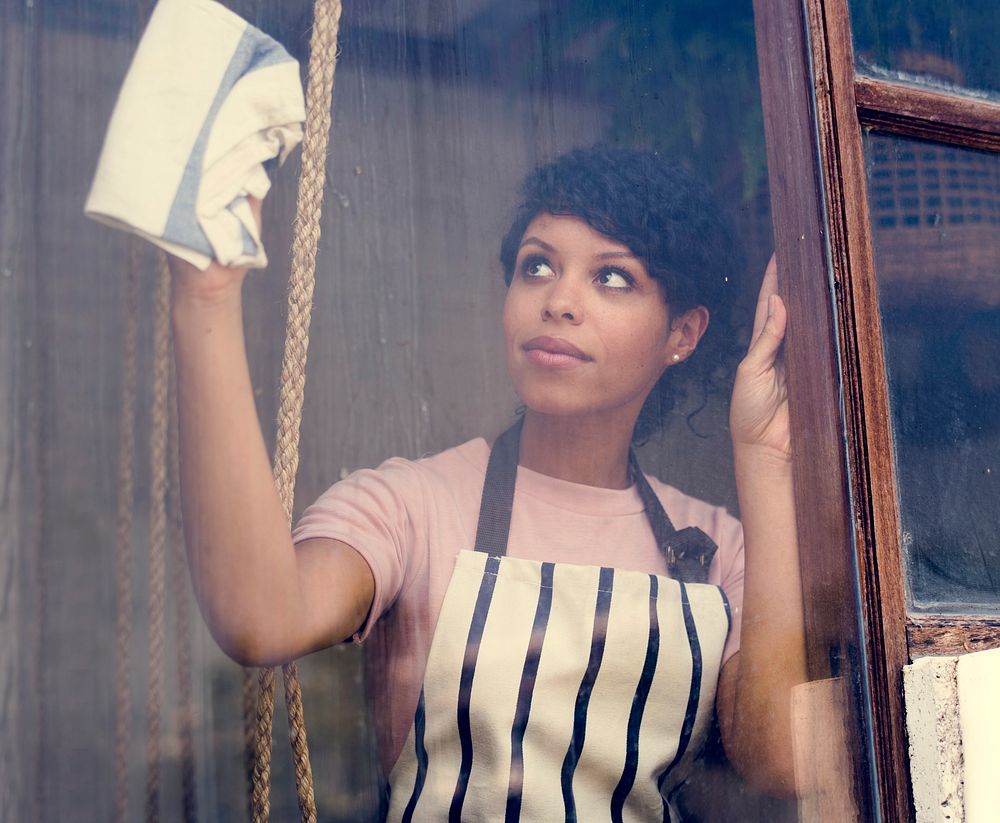 African descent wearing apron for cleaning window
