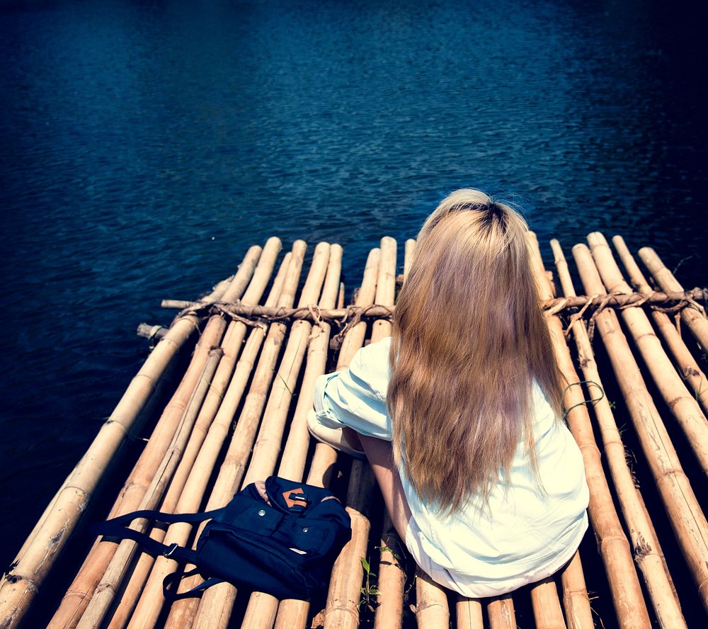 Backpack Traveler Woman is on a raft in a lake