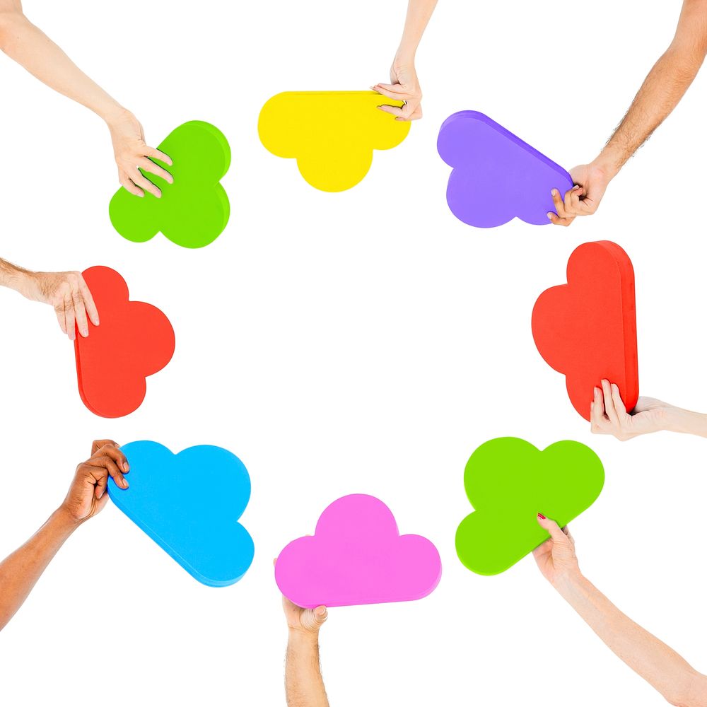 Hands holding multi colored cloud shaped speech bubbles.