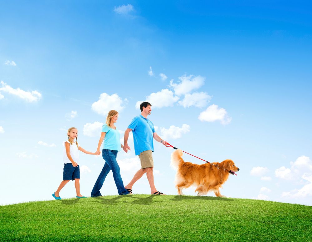 Family Walking Together with Their Pet Dog Outdoors
