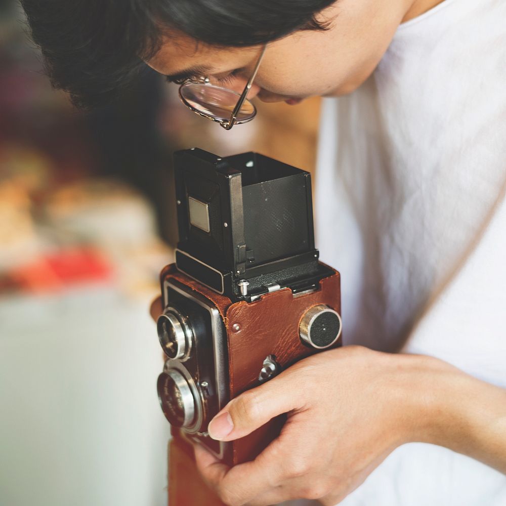 Young guy taking photos with a vintage camera