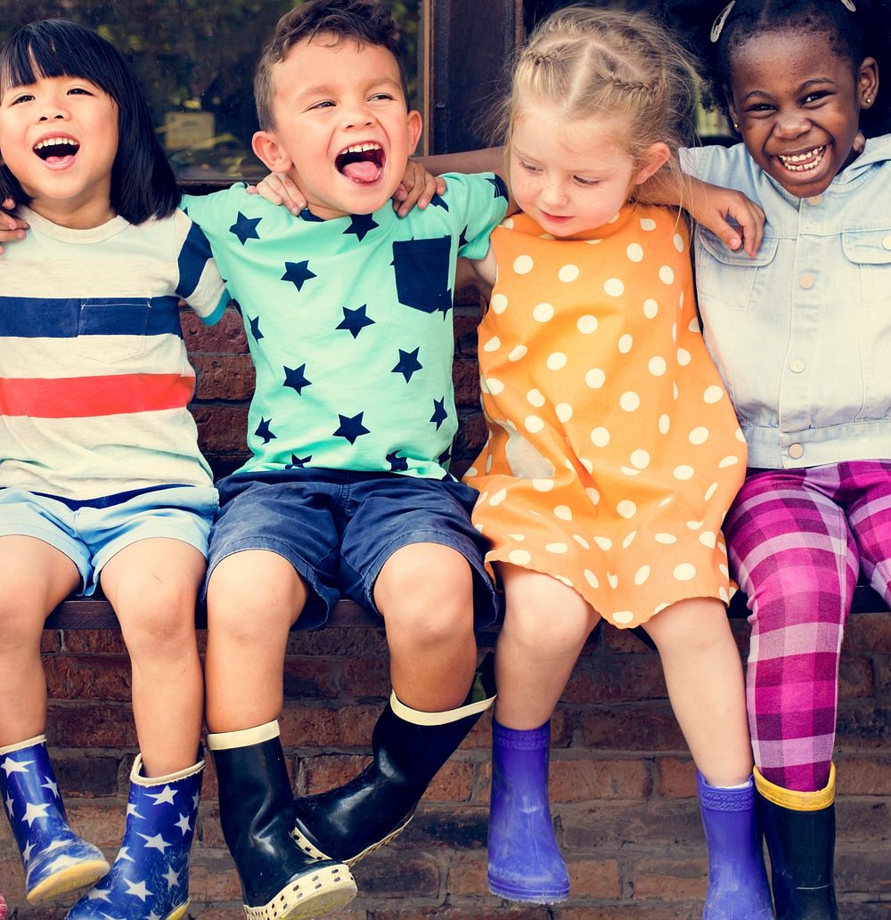 Group of kindergarten kids friends arm around sitting and smilin