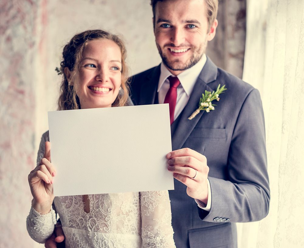 Bride and groom holding blank placard