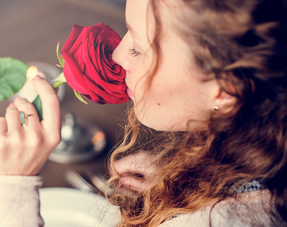 Woman holding flower and smelling it