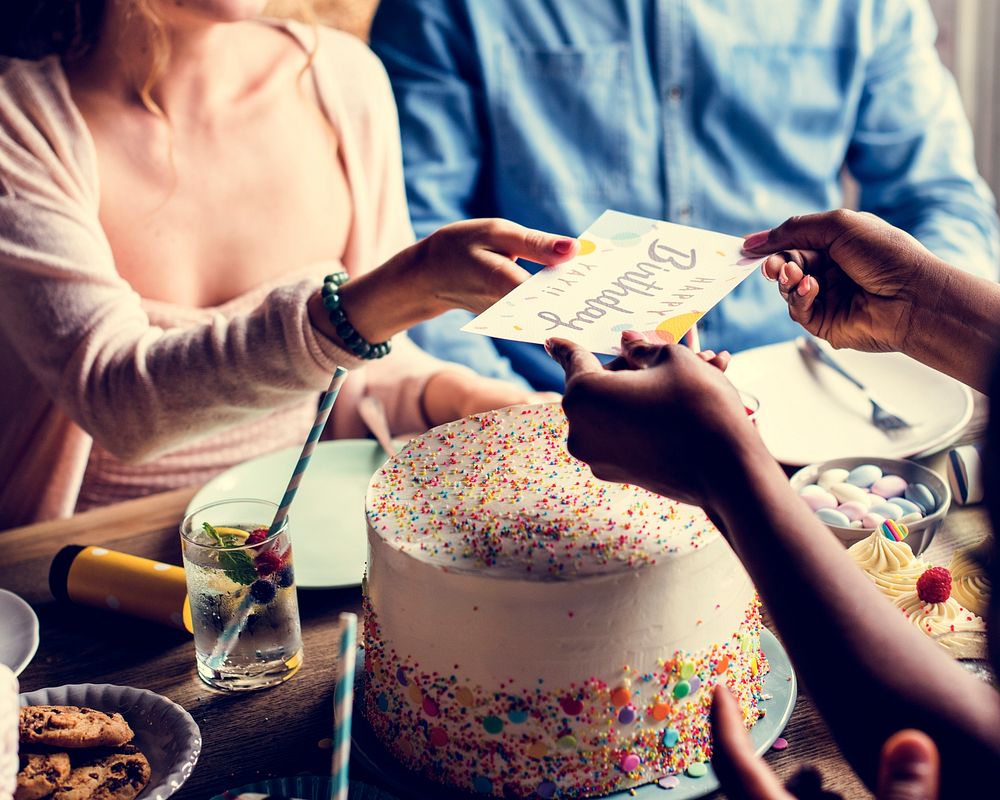 People celebrate birthday party with cake and card