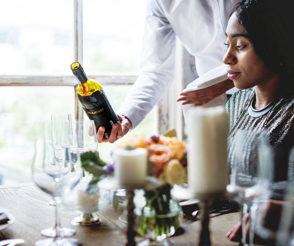 Restaurant Staff Serving Red Wine to Customers