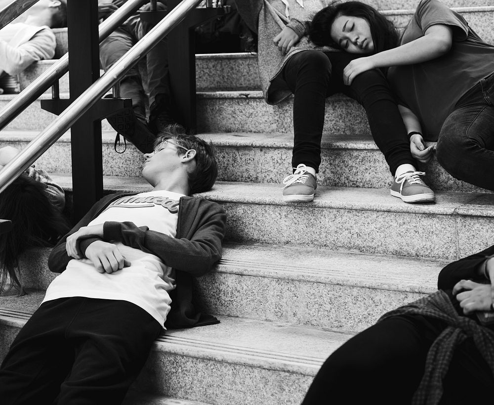 Young students sleeping on the staircase