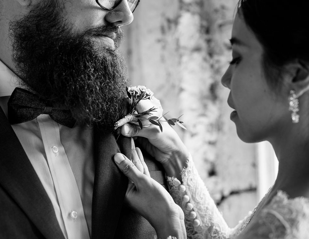 Bride Put on Small Flower Bouqet on Groom Tuxedo