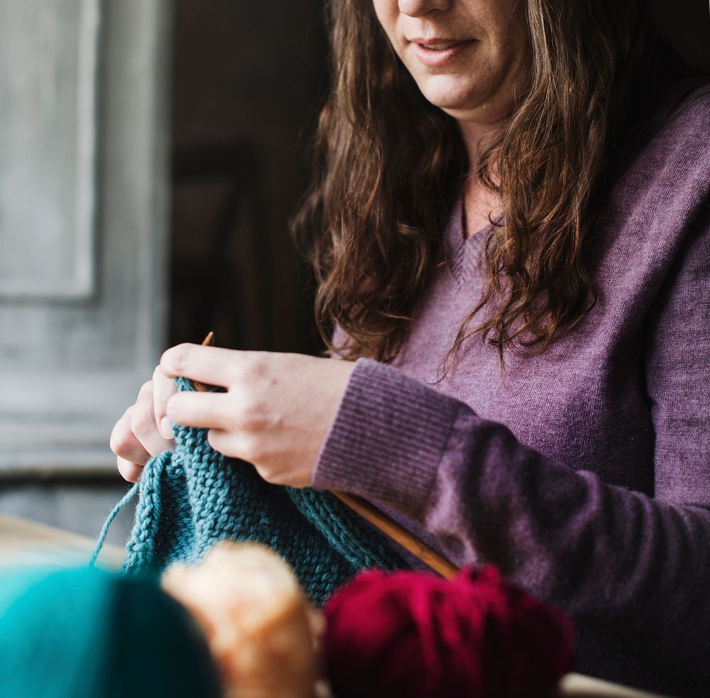 Caucasian woman leisure knitting on wooden table