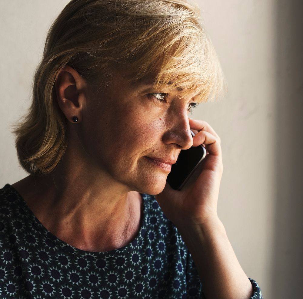 Closeup of caucasian woman calling mobile phone with thoughtful face expression