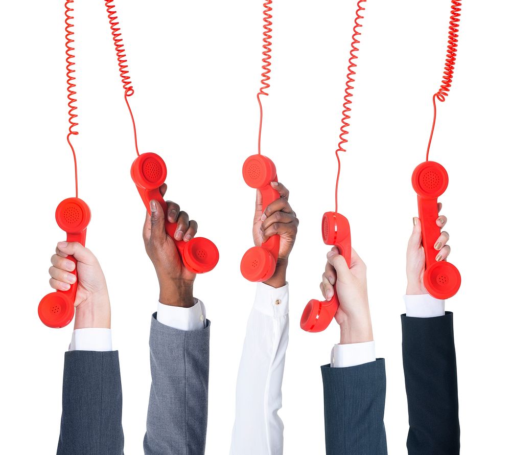 Business people holding red telephone.