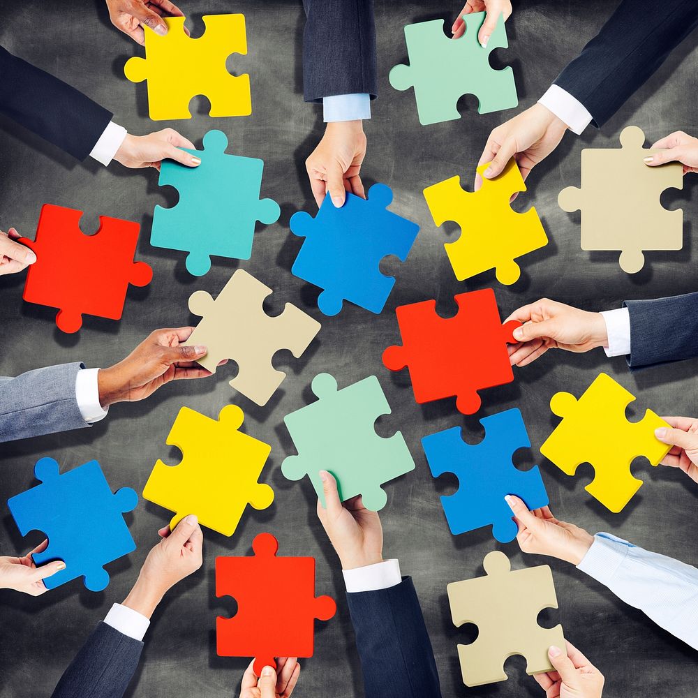 Group of Hands Holding Colorful Jigsaw Pieces
