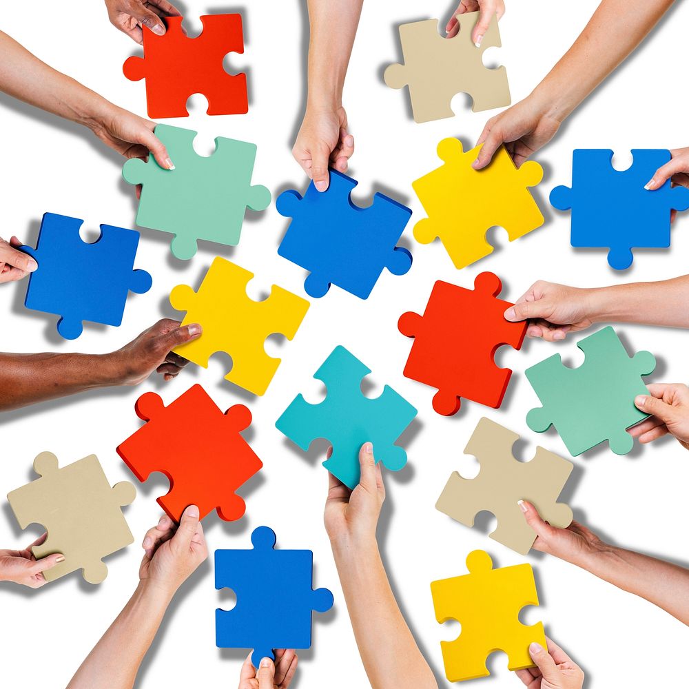 Group of Hands Holding Jigssaw Puzzle