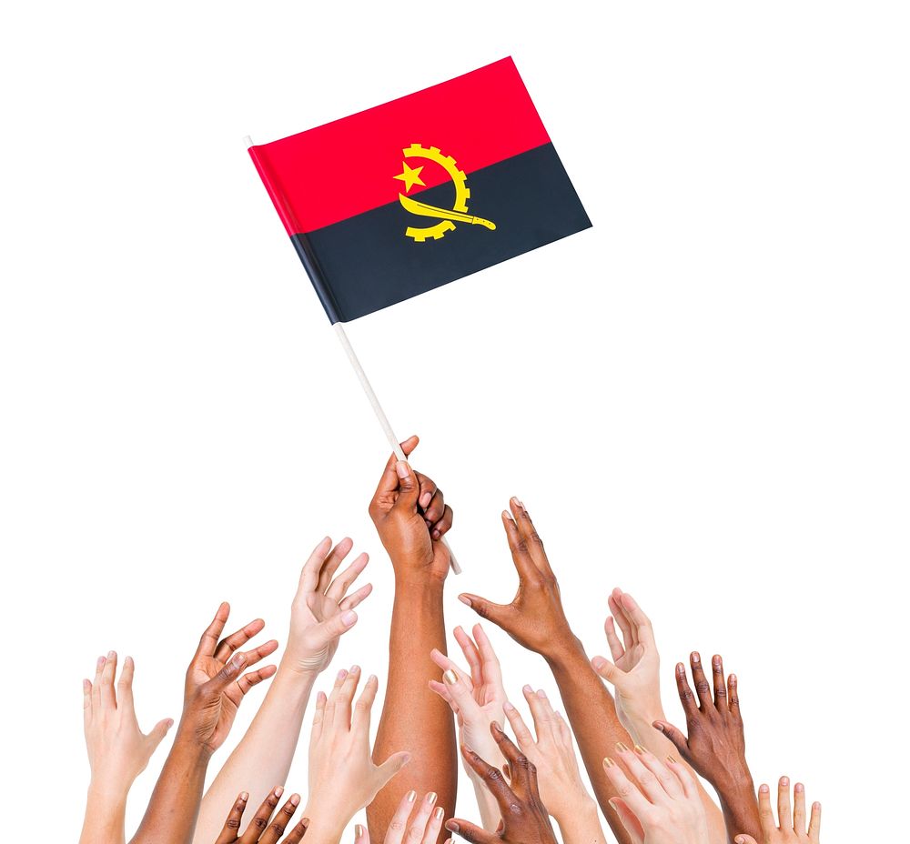 Group of people reaching for and holding the Angolan flag.