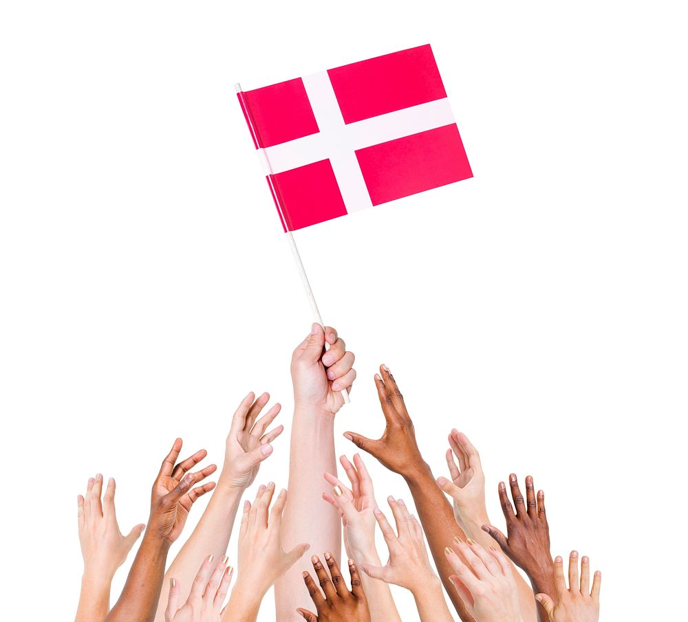 Group of multi-ethnic people reaching for and holding the flag of Denmark.