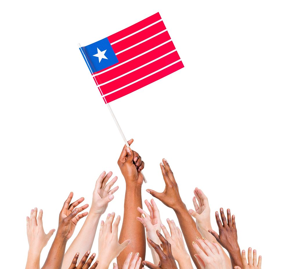 Group of multi-ethnic people reaching for and holding the flag of Liberia.