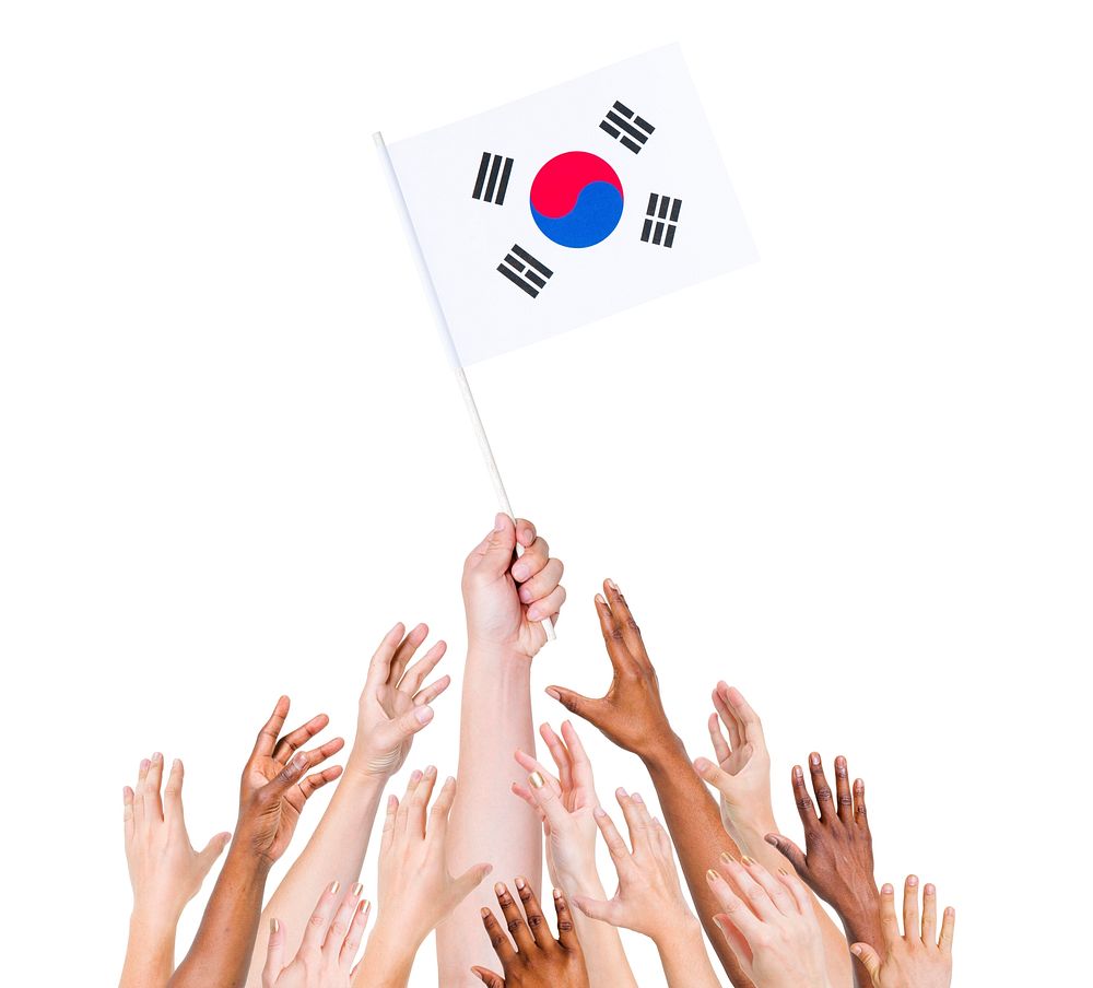 Human hand holding South Korea Flag among group of multi-ethnic hands