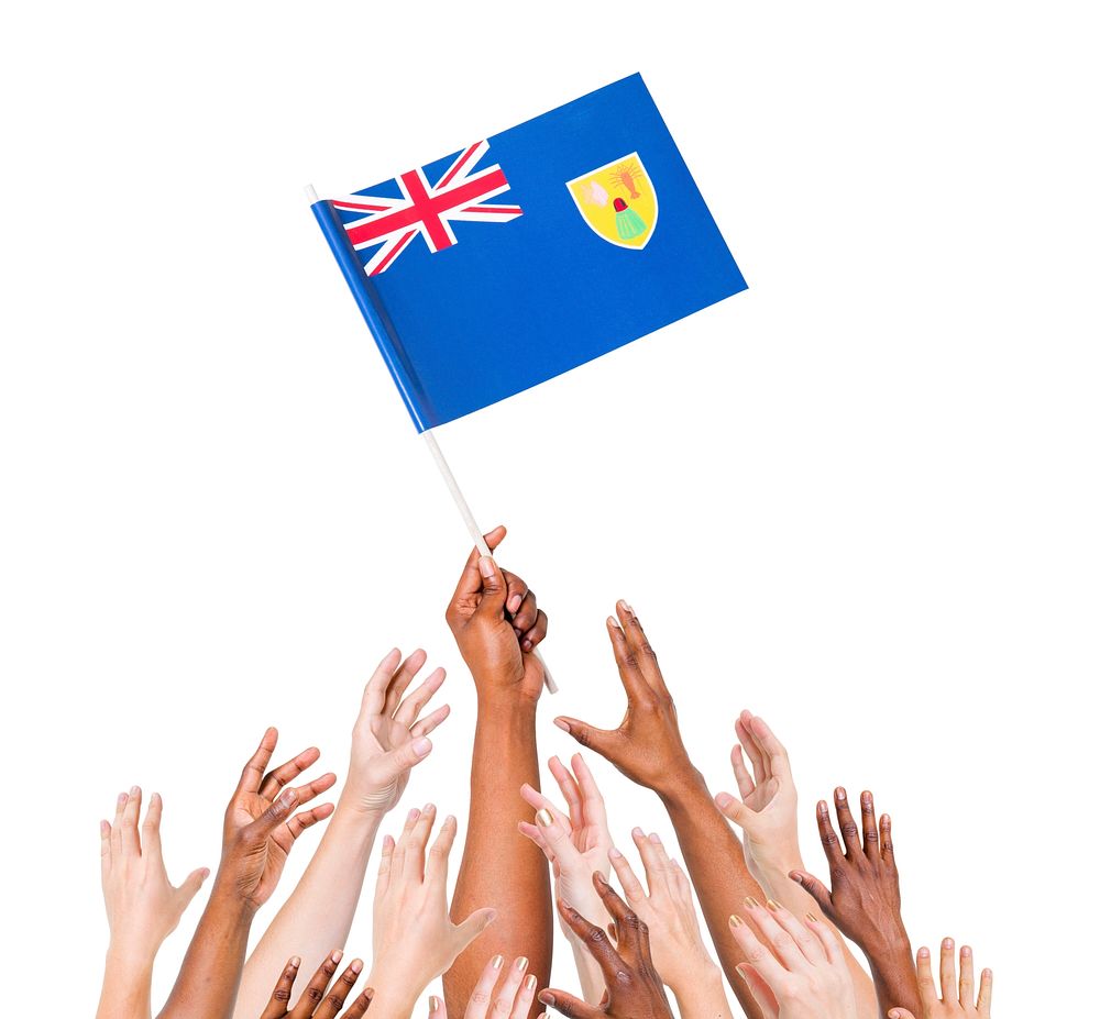 Human hand holding Turks and Caicos Islands flag among multi-ethnic group of people's hand