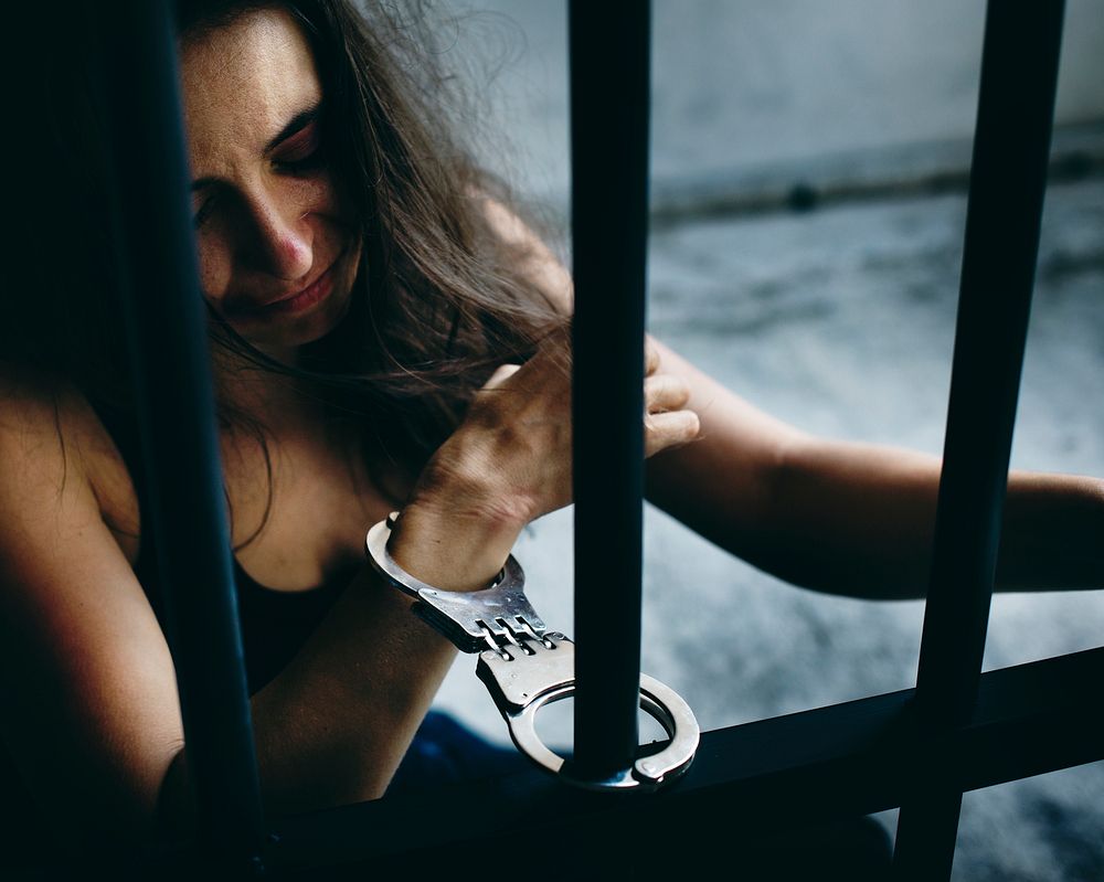 Woman handcuffed to a prison bar