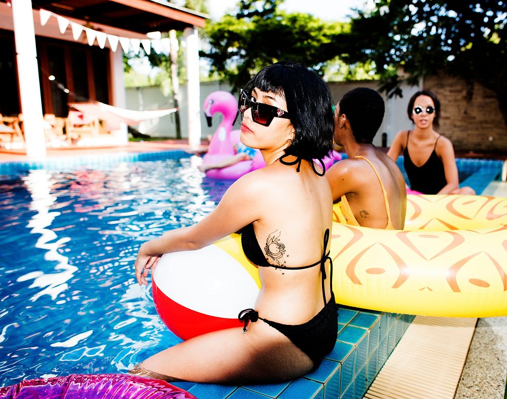Closeup of Asian woman sitting by the pool with friends