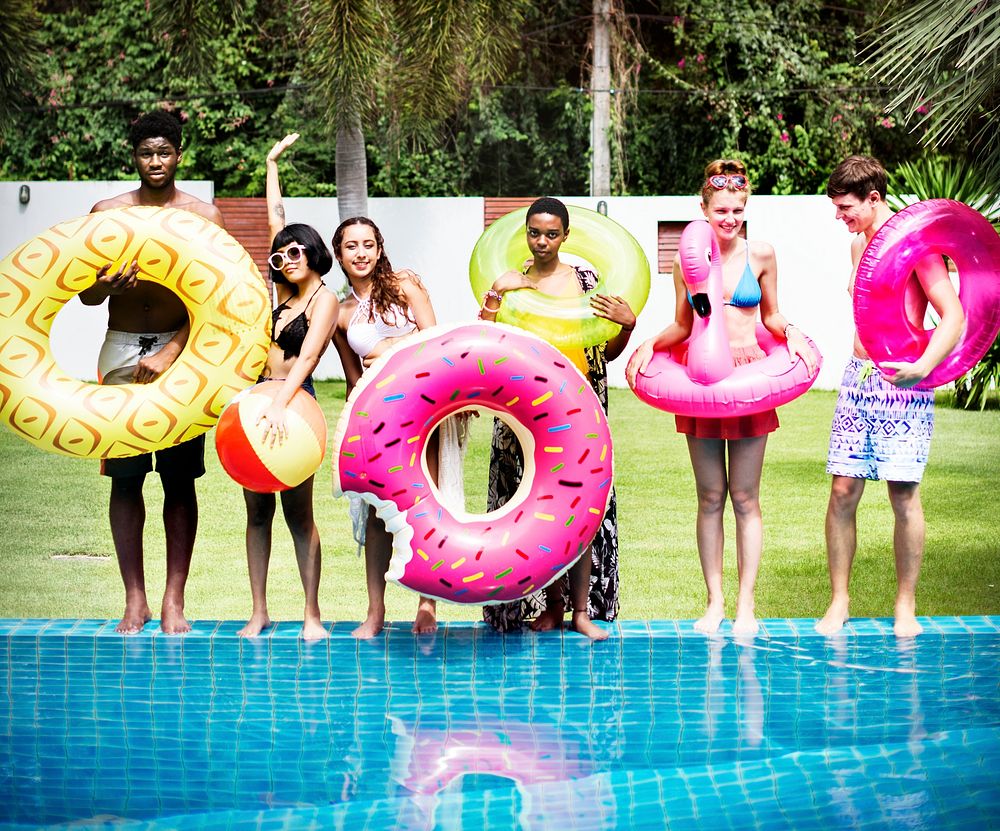 Group of diverse friends standing by the swimming pool
