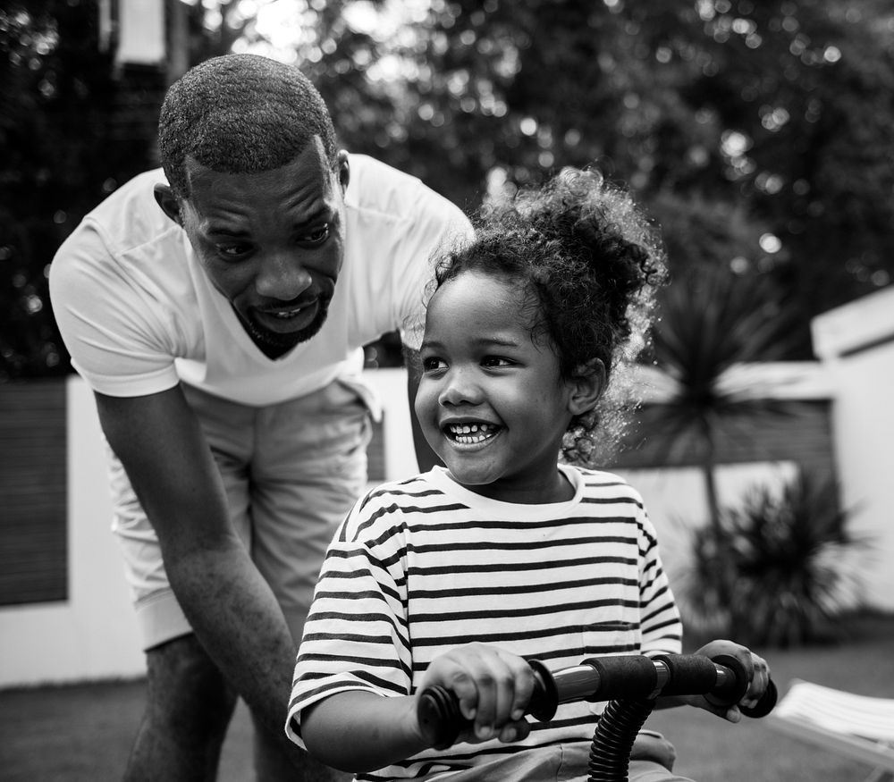 Father teaches daughter to ride a bicycle