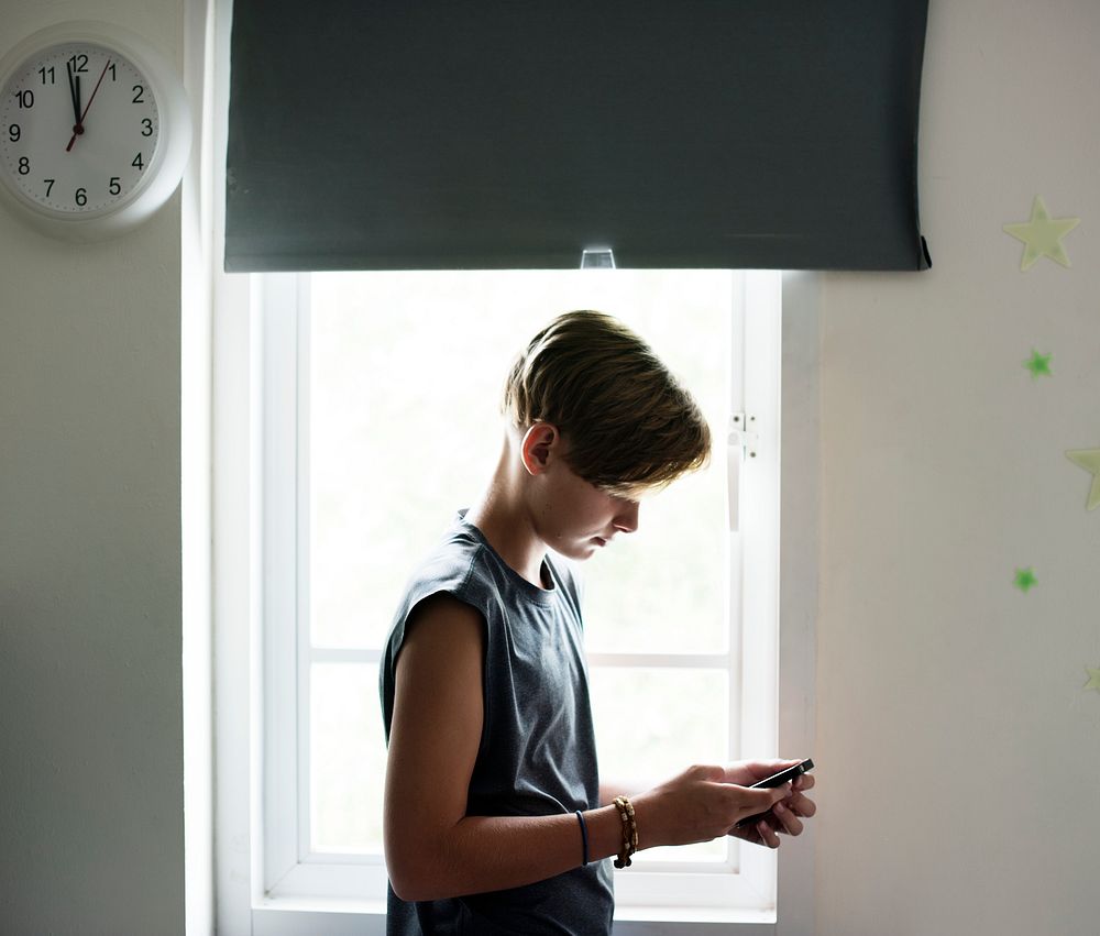 Young caucasian boy using mobile phone