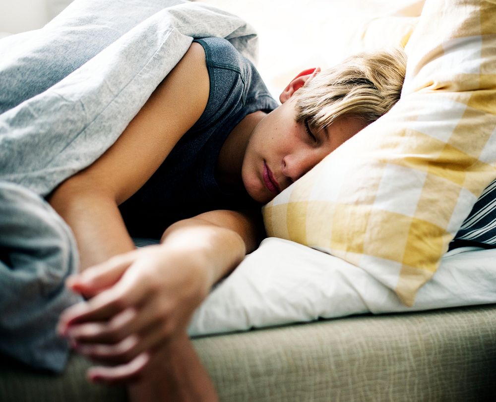 Young caucasian boy sleeping in bed