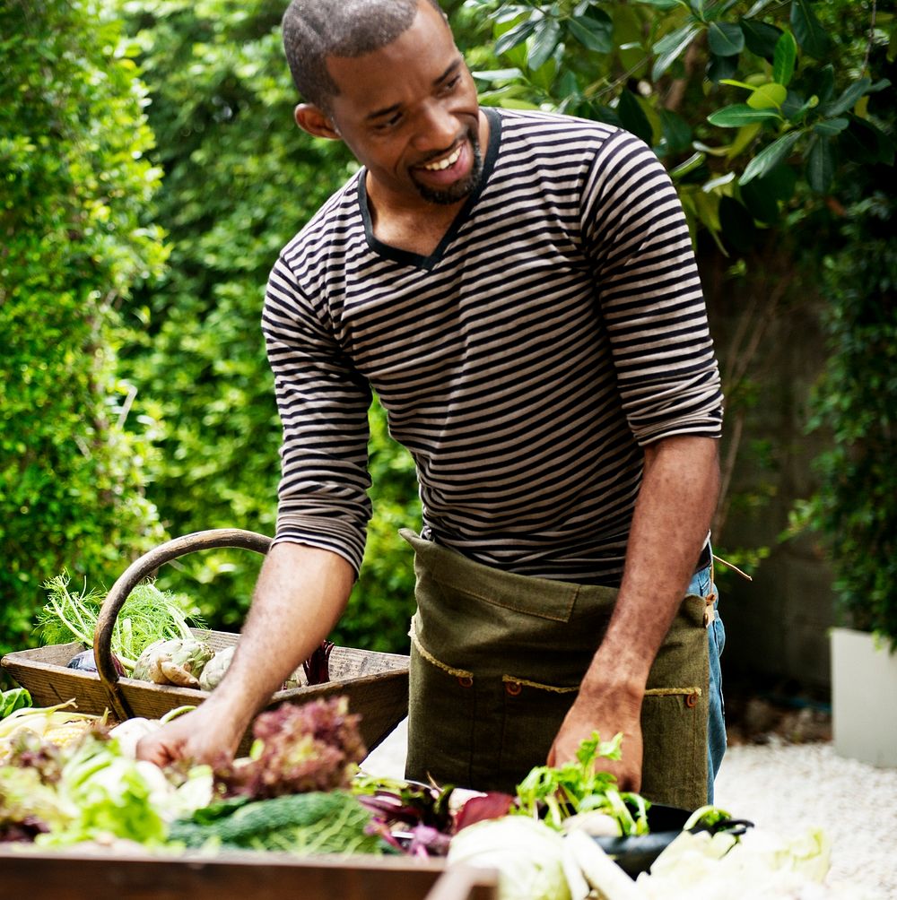 African descent man with various fresh organic vegetable