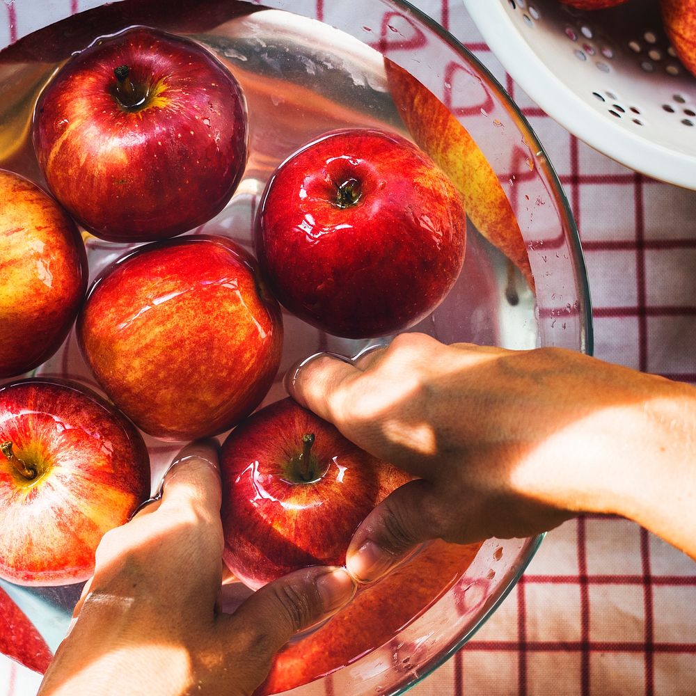 Aerial view of hands washing apples in bowl