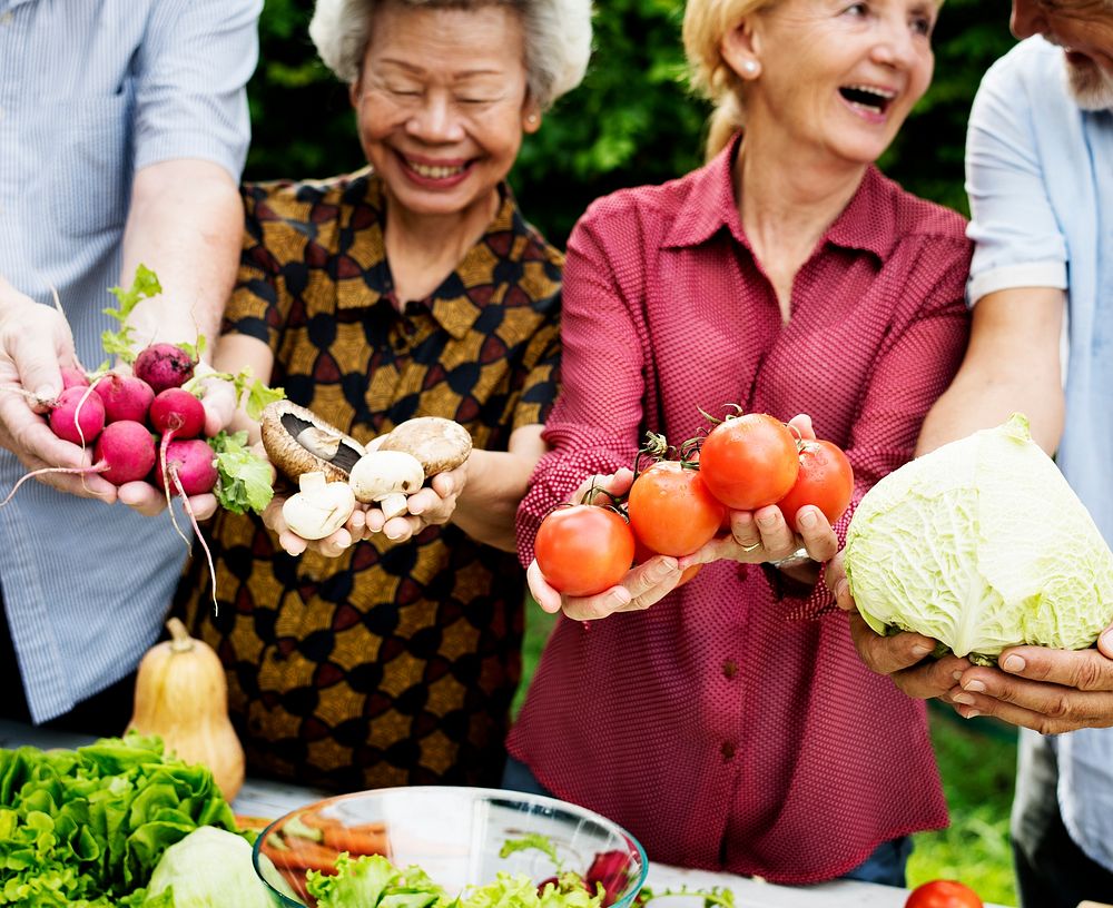 Diverse senior people holding vegetables in their hands