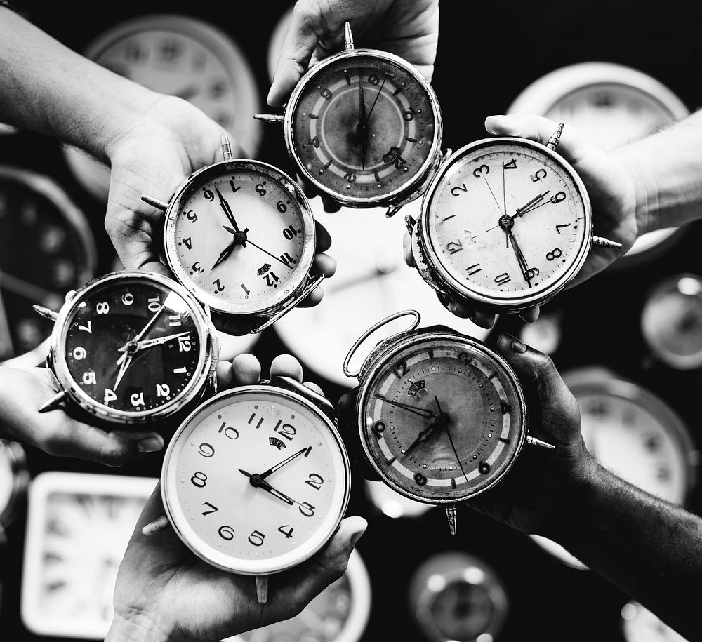 Closeup of hands holding clocks grayscale