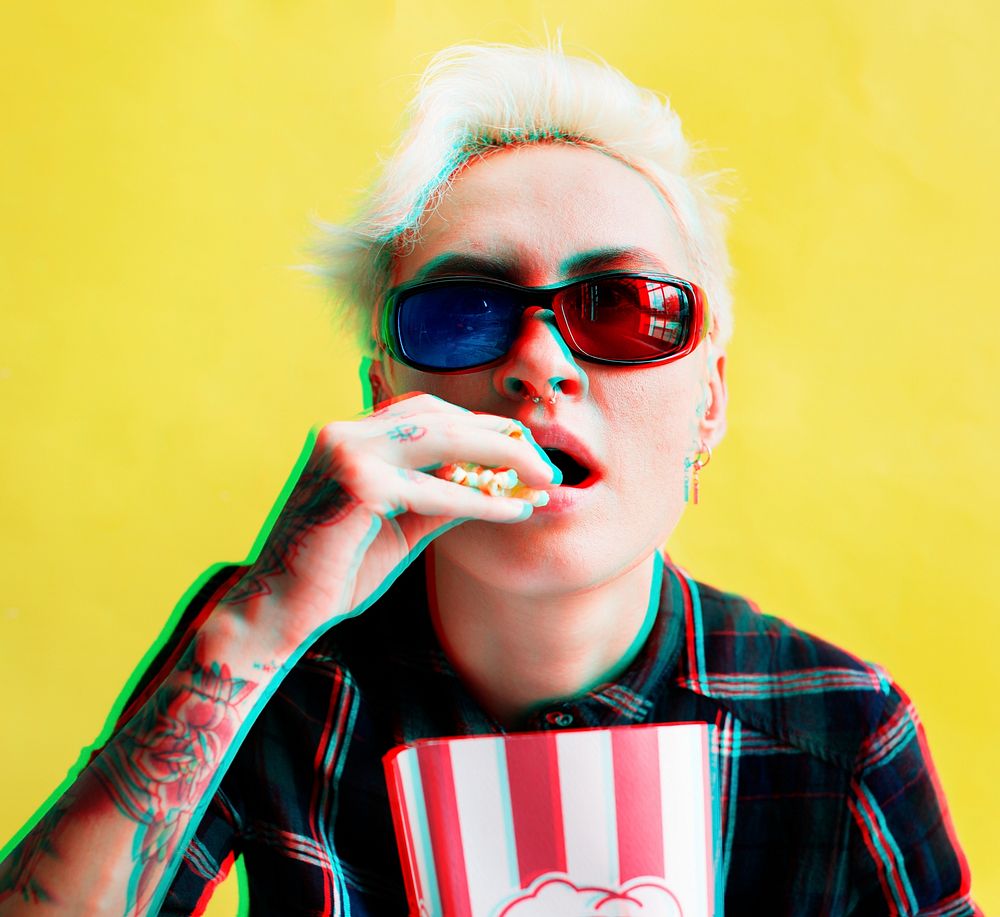 Caucasian tattoo woman with 3D glasses eating pop-corn