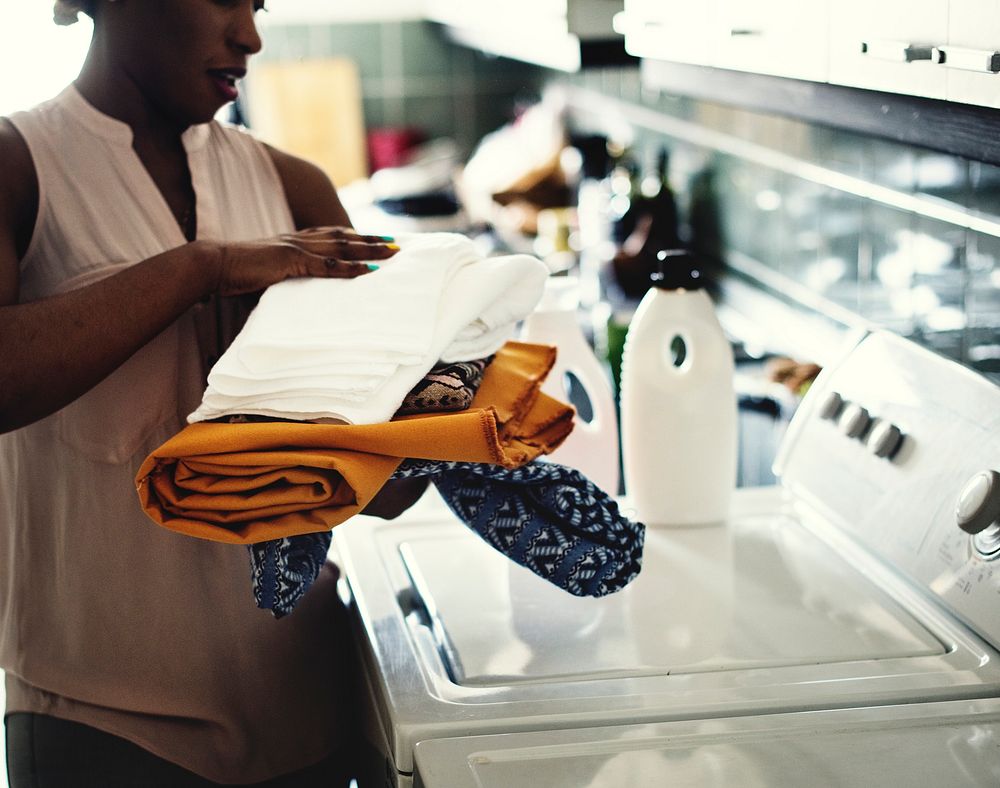 Black woman using washing machine doing the laudry