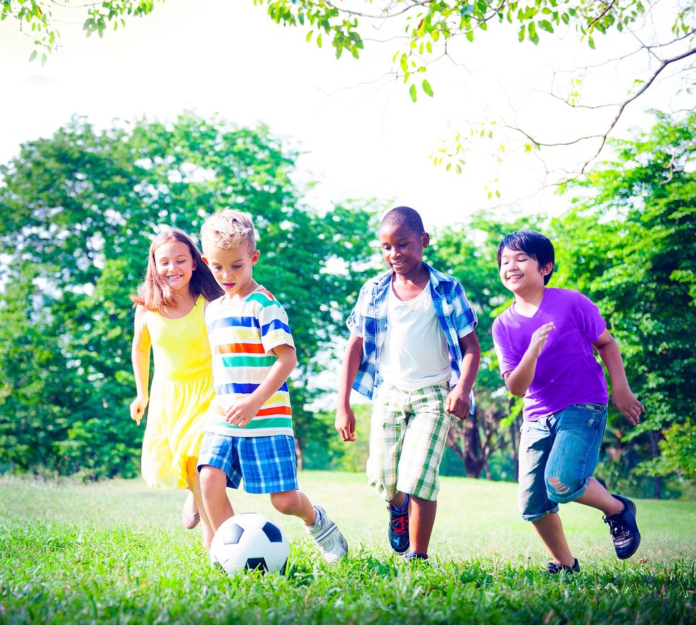 Children playing Football at park.