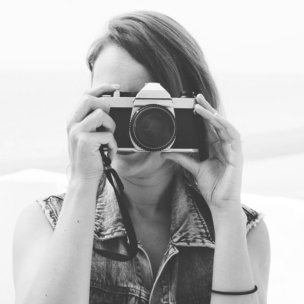 Closeup of woman using camera taking photo grayscale