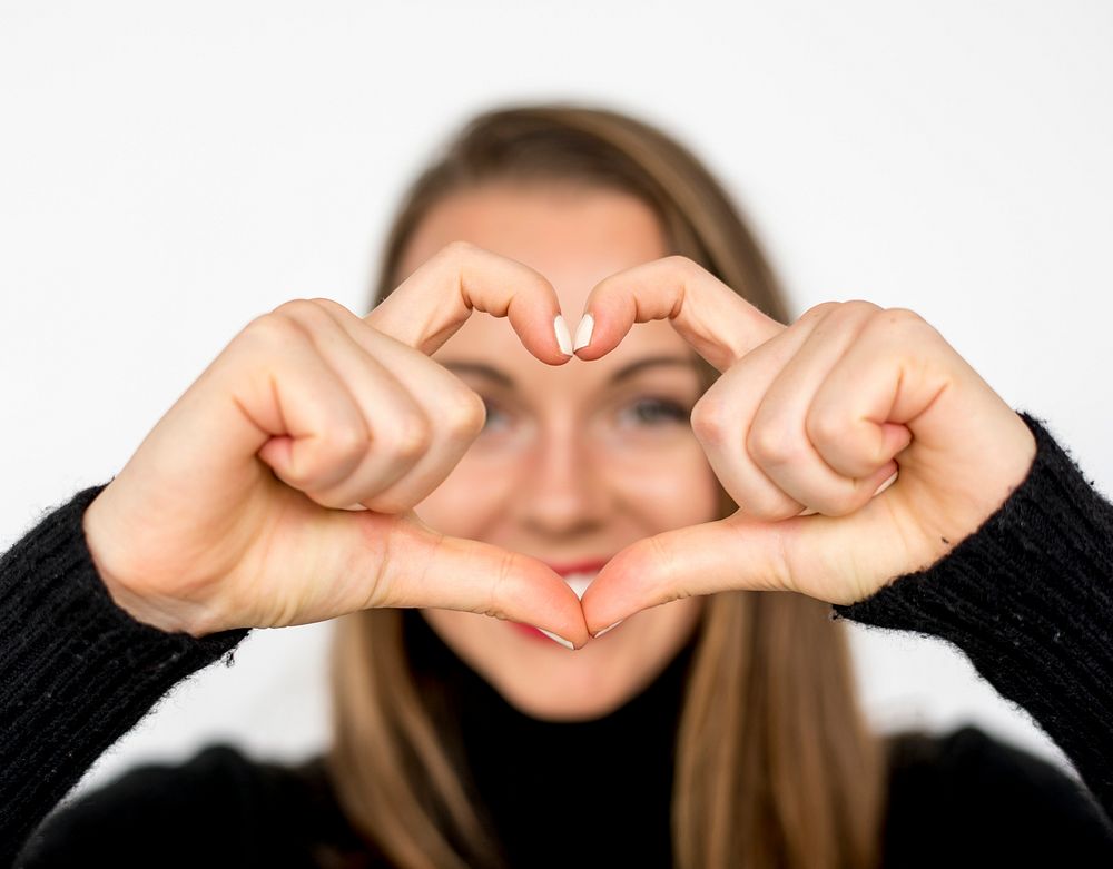 Woman doing the heart hand symbol